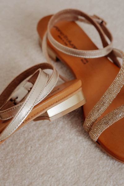 Flache Sandale mit asymmetrischem Riemen in Gold