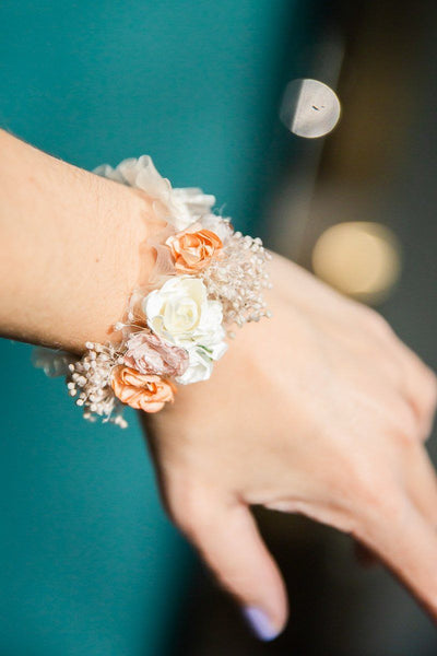 Elastisches Armband mit Textilblüten in Rosétönen und echtem Schleierkraut an Handgelenkl